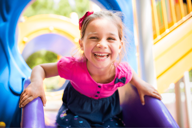 Pediatric Dentist In Philadelphia, Pa 12 A Happy Girl On A Playground Slide, One Of The Kids Our Philadelphia Pediatric Dentistry Team Cares For