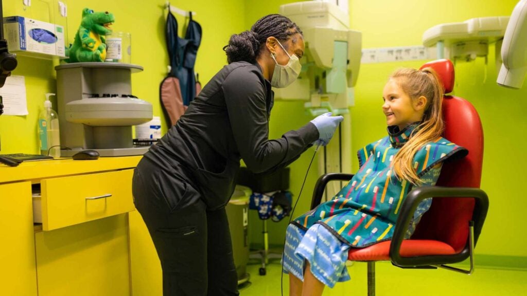 Pediatric Restorative Dentistry 1 A Hygienist Cleaning A Young Girl'S Teeth At Cobblestone Kids