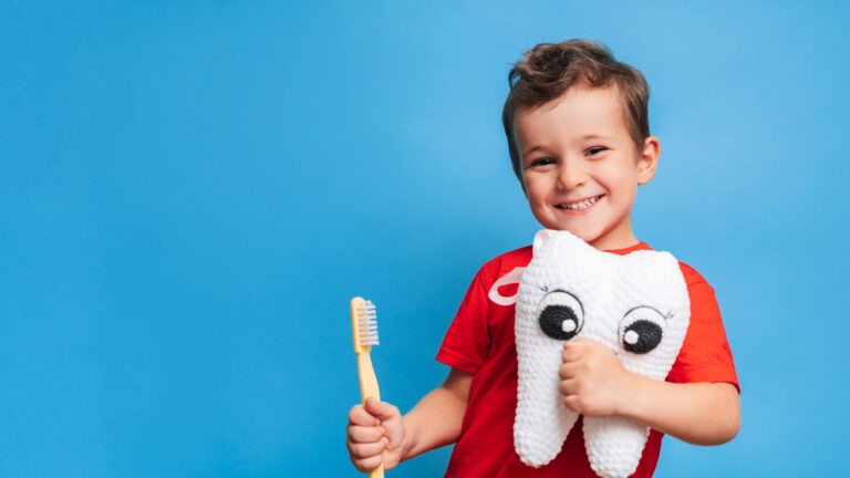 Boy Holding A Toothbrush And Plush Tooth